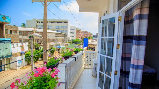 Un balcón con plantas en macetas y vistas a edificios vecinos.