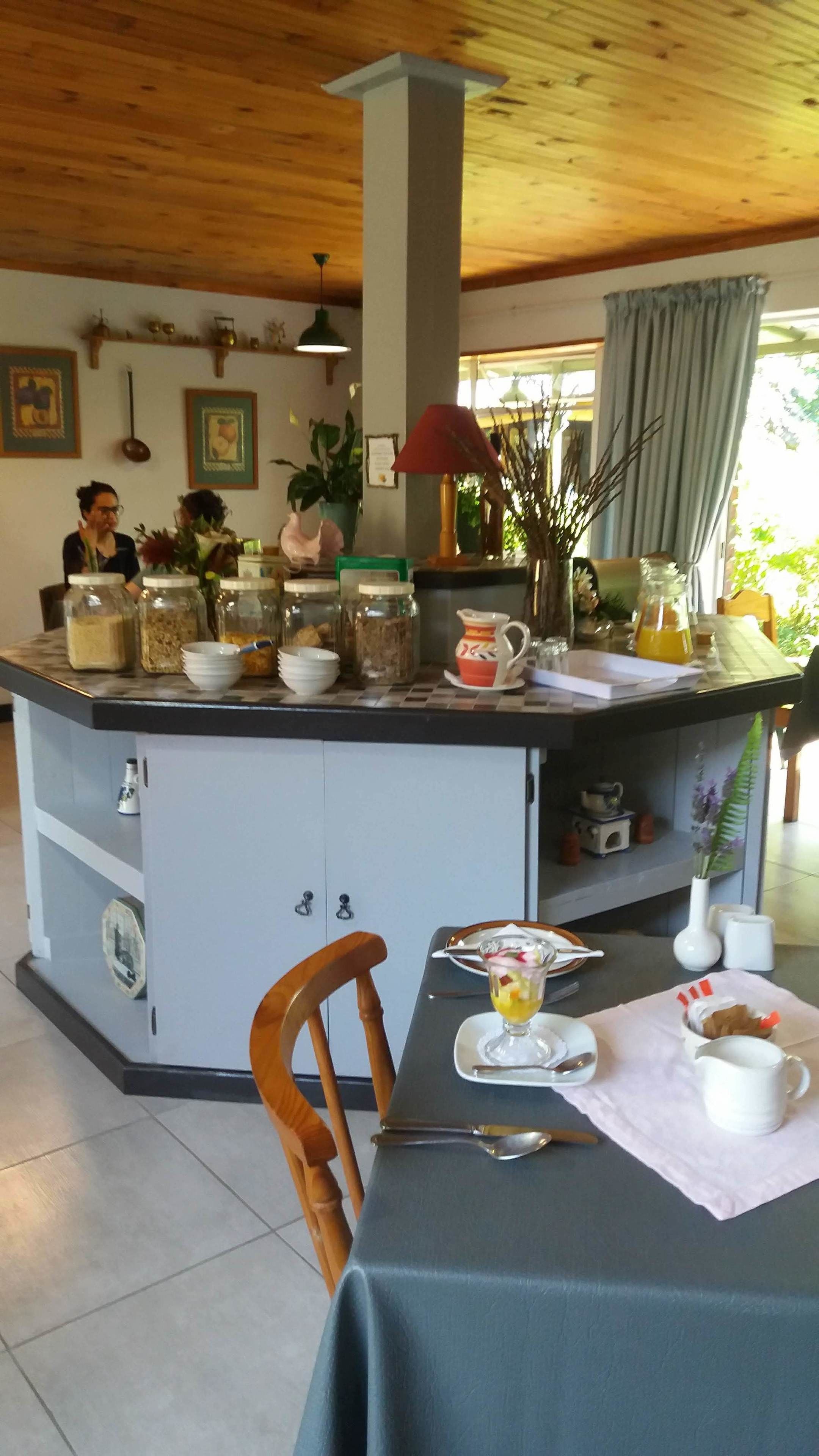 Une cuisine dotée d’un îlot central, d’un plafond en bois et de divers ustensiles de cuisine.