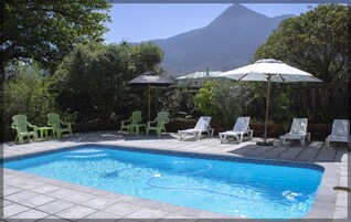 Una piscina al aire libre, sillones reclinables de piscina
