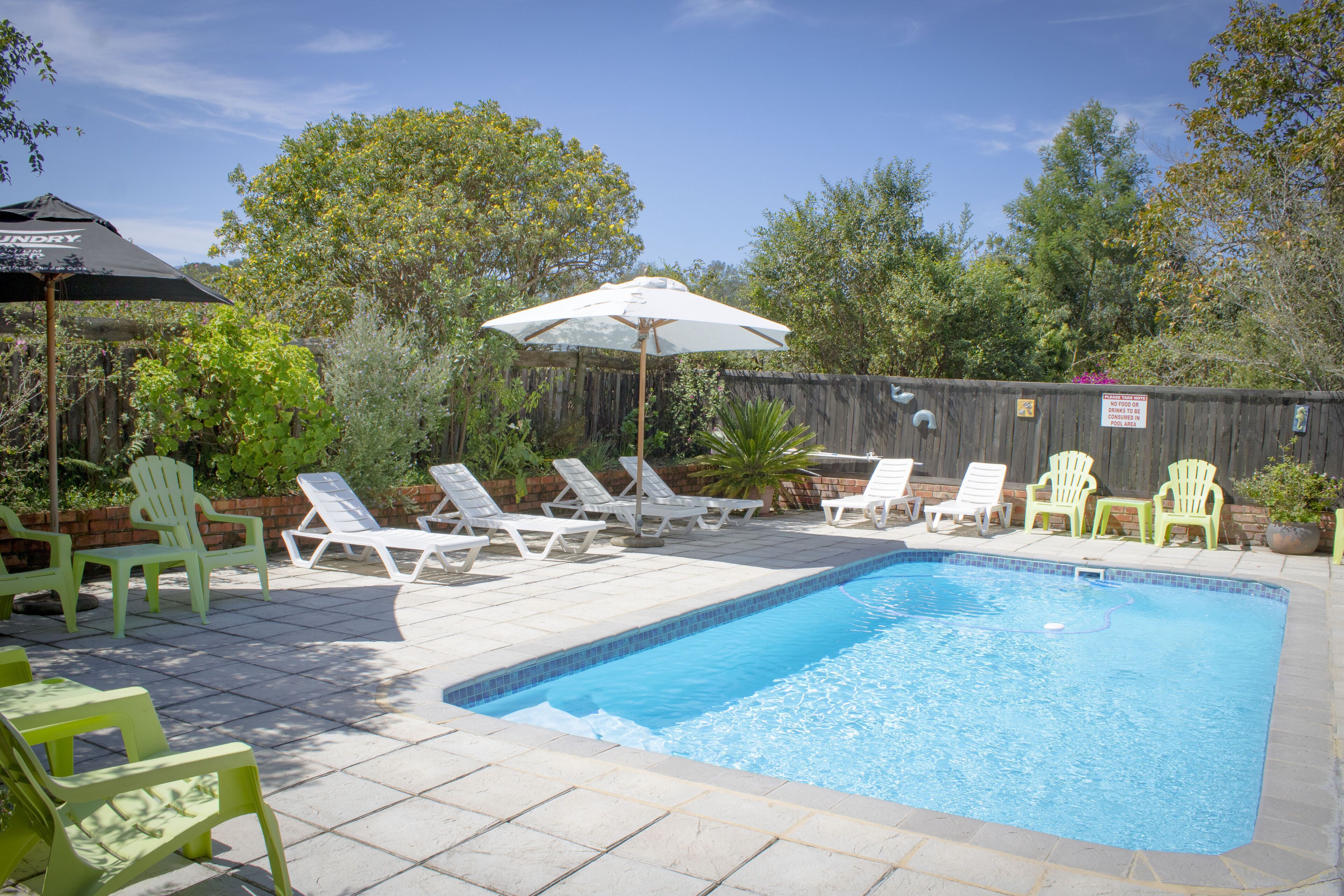 A swimming pool with lounge chairs and umbrellas.