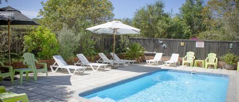 A swimming pool with lounge chairs and umbrellas.