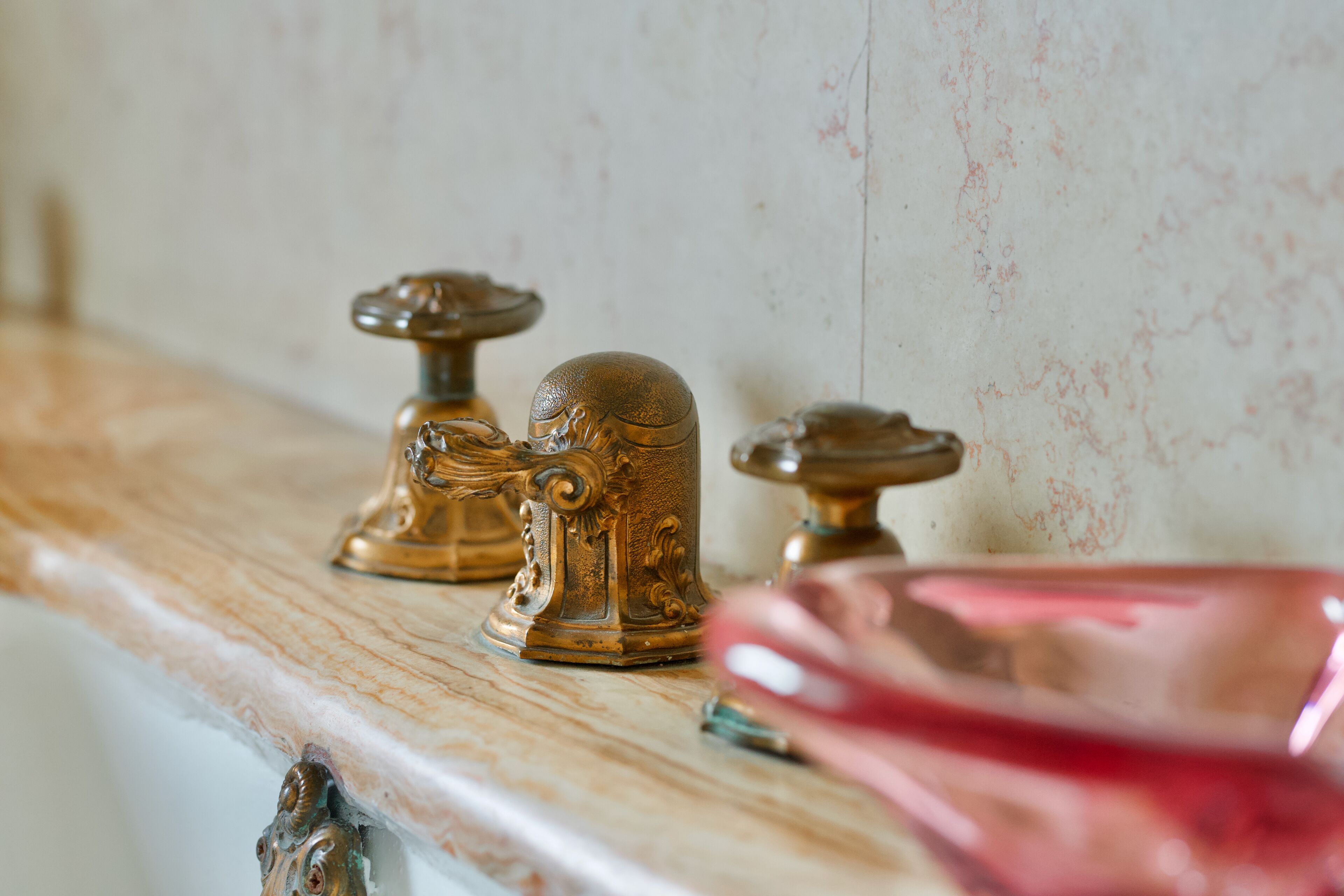 A marble countertop with ornate brass fixtures.
