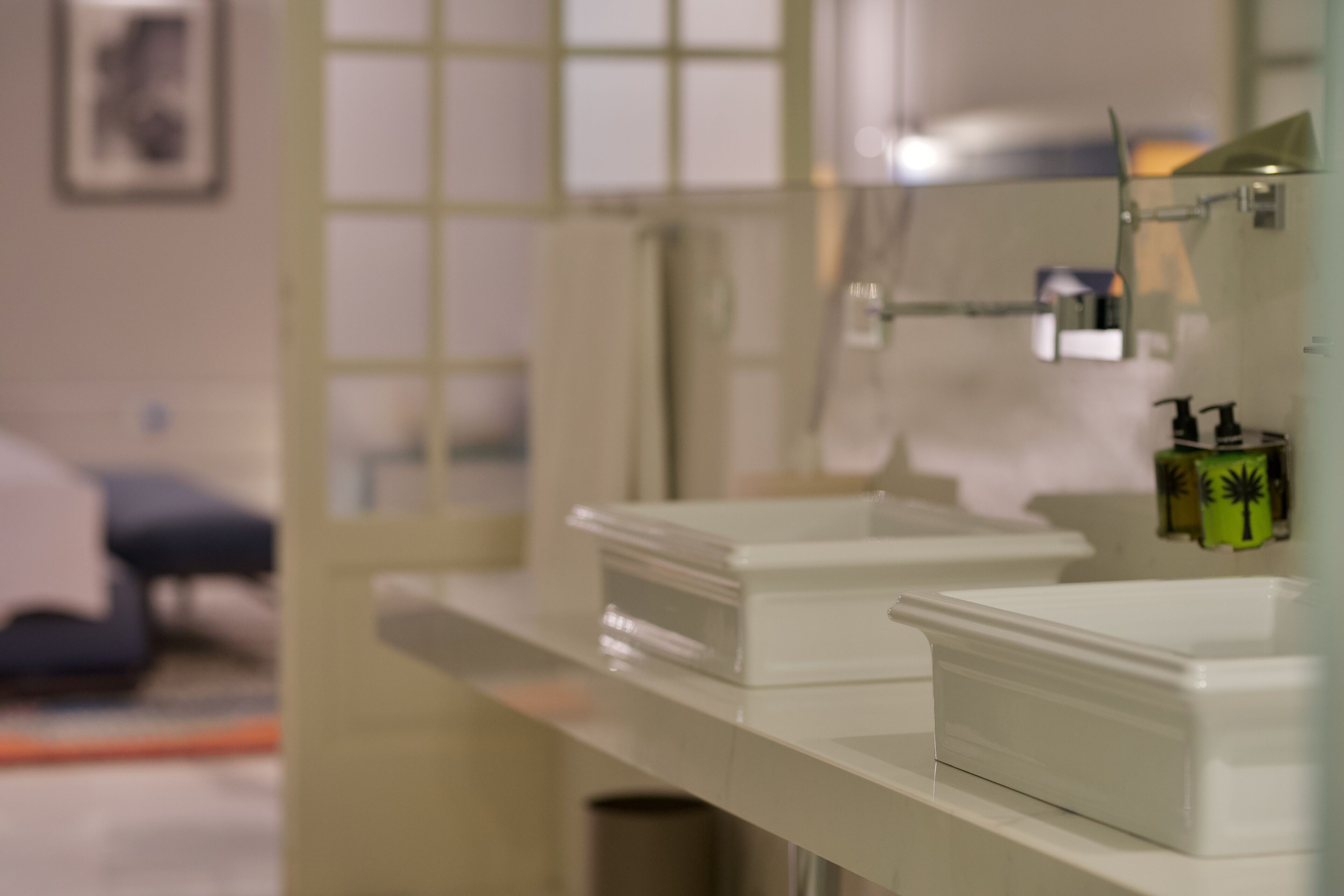 A bathroom with a white countertop, a mirror, and a shower area.