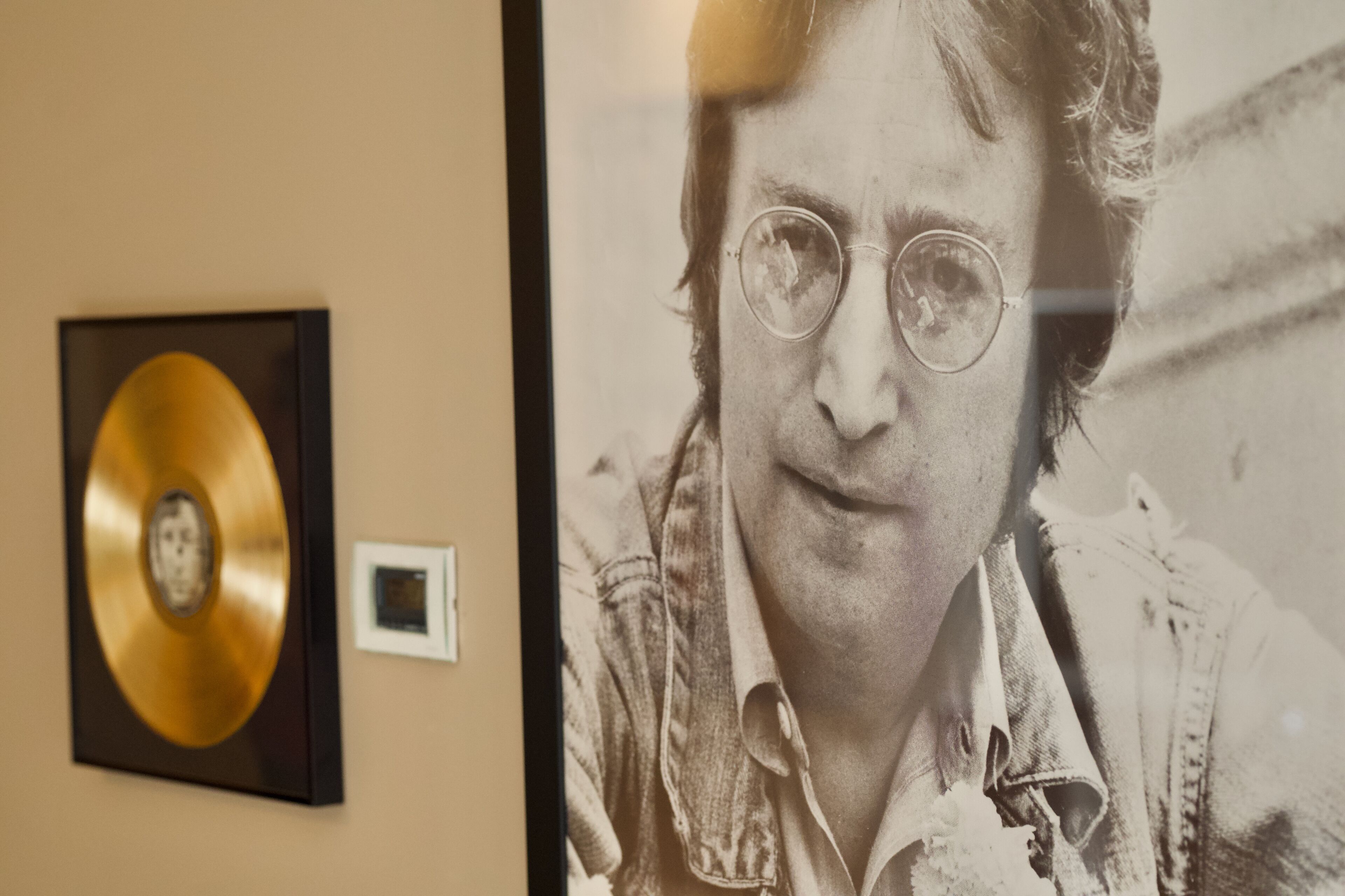 Fotografía enmarco de una persona con un disco de oro en la pared.