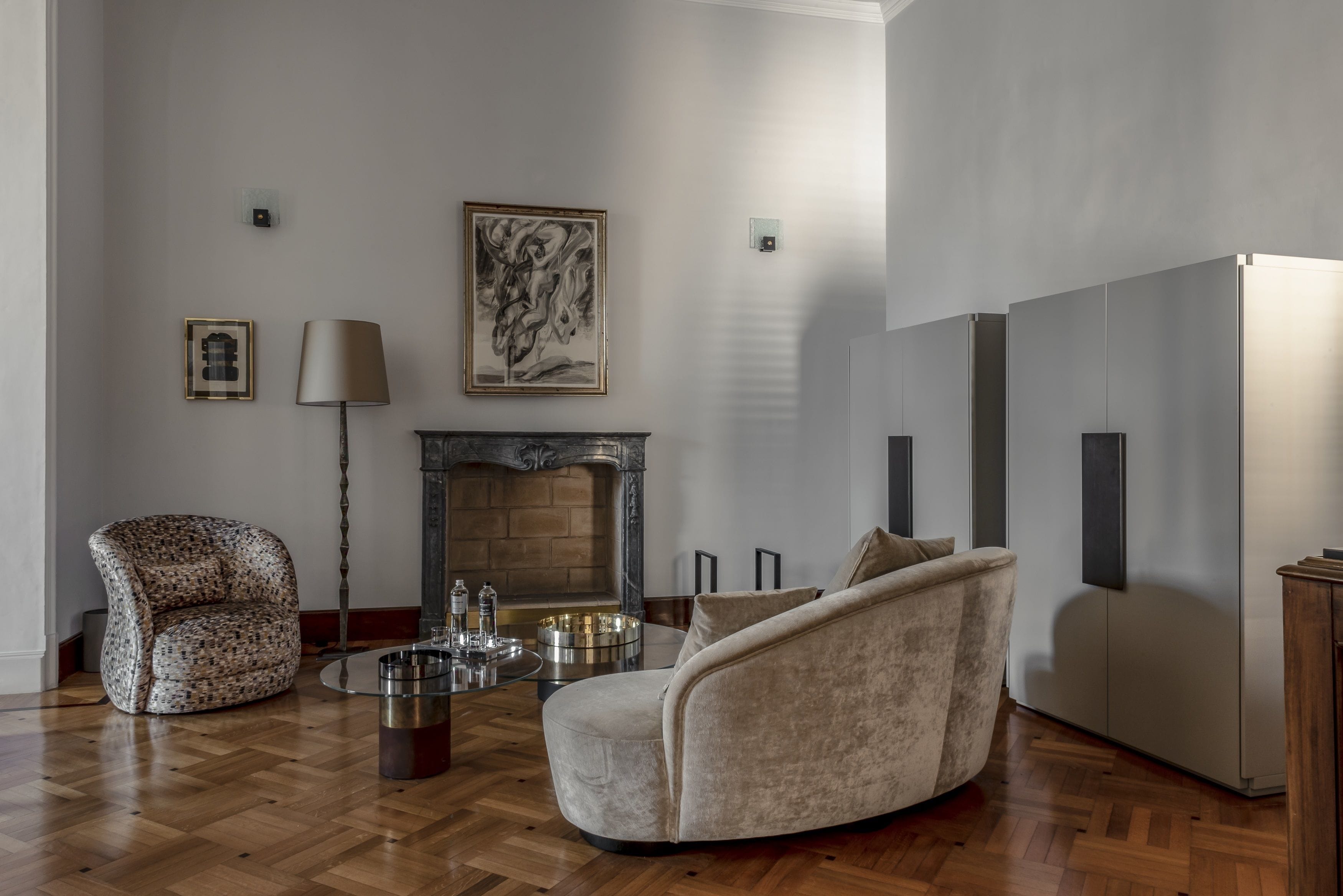 Una sala de estar con chimenea, un sillón estampado, un sofá y una mesa de centro.