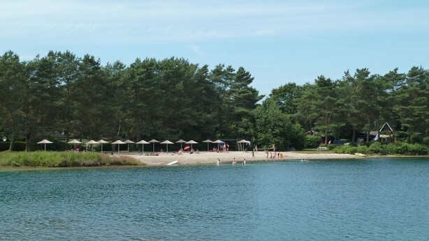 A lakeside beach with umbrellas and people. - **** Only roof house **** lovingly furnished    (Wiefelstede)