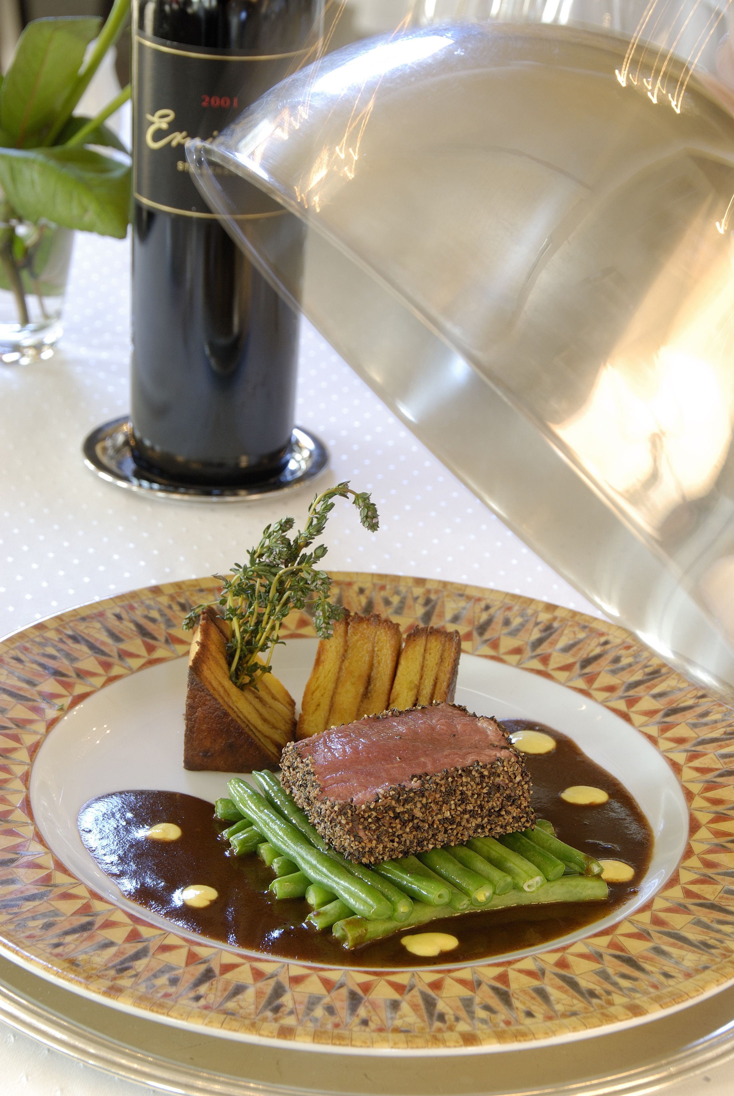 Un plato de comida con bistec, judías verdes y patatas asadas.