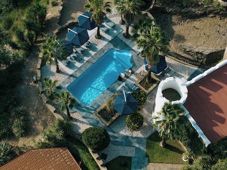 Una piscina al aire libre, sillones reclinables de piscina