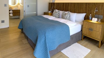 Une chambre moderne avec un grand lit, une tête de lit en bois, des tables de chevet avec des lampes et une armoire intégrée.
