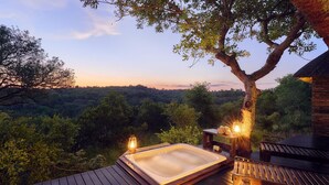 A hot tub on a wooden deck with a view of a forested landscape. - Parsons Hilltop Safari Camp (Hoedspruit)