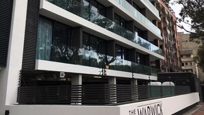 Edifício de vários andares com design arquitetônico moderno, com grandes janelas e um letreiro de nome bem visível.