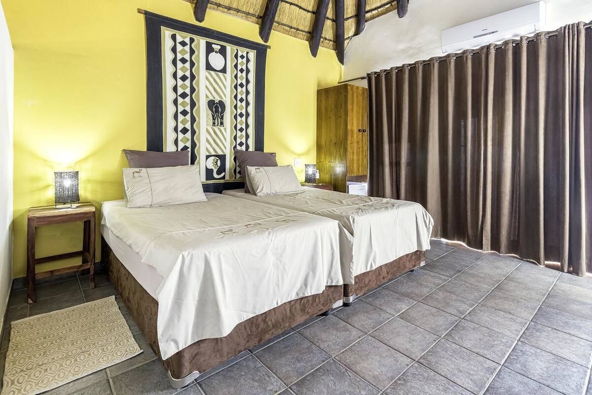 A double bed with a wooden headboard, a bedside table, and a wall-mounted artwork.