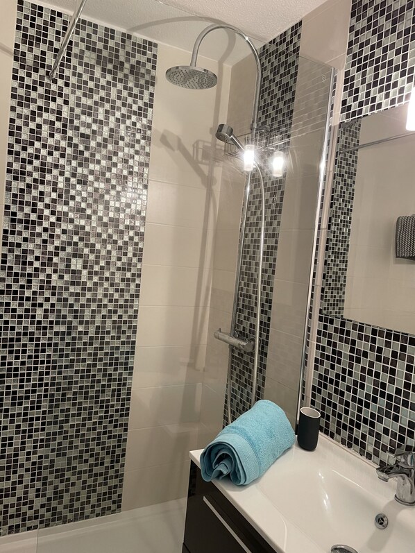 Een douche, een haardroger, handdoeken, toiletpapier