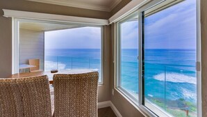 A balcony with wicker chairs and a table overlooking the ocean. - Oceanfront Balcony with Heated Pool & Hot Tub (Solana Beach)