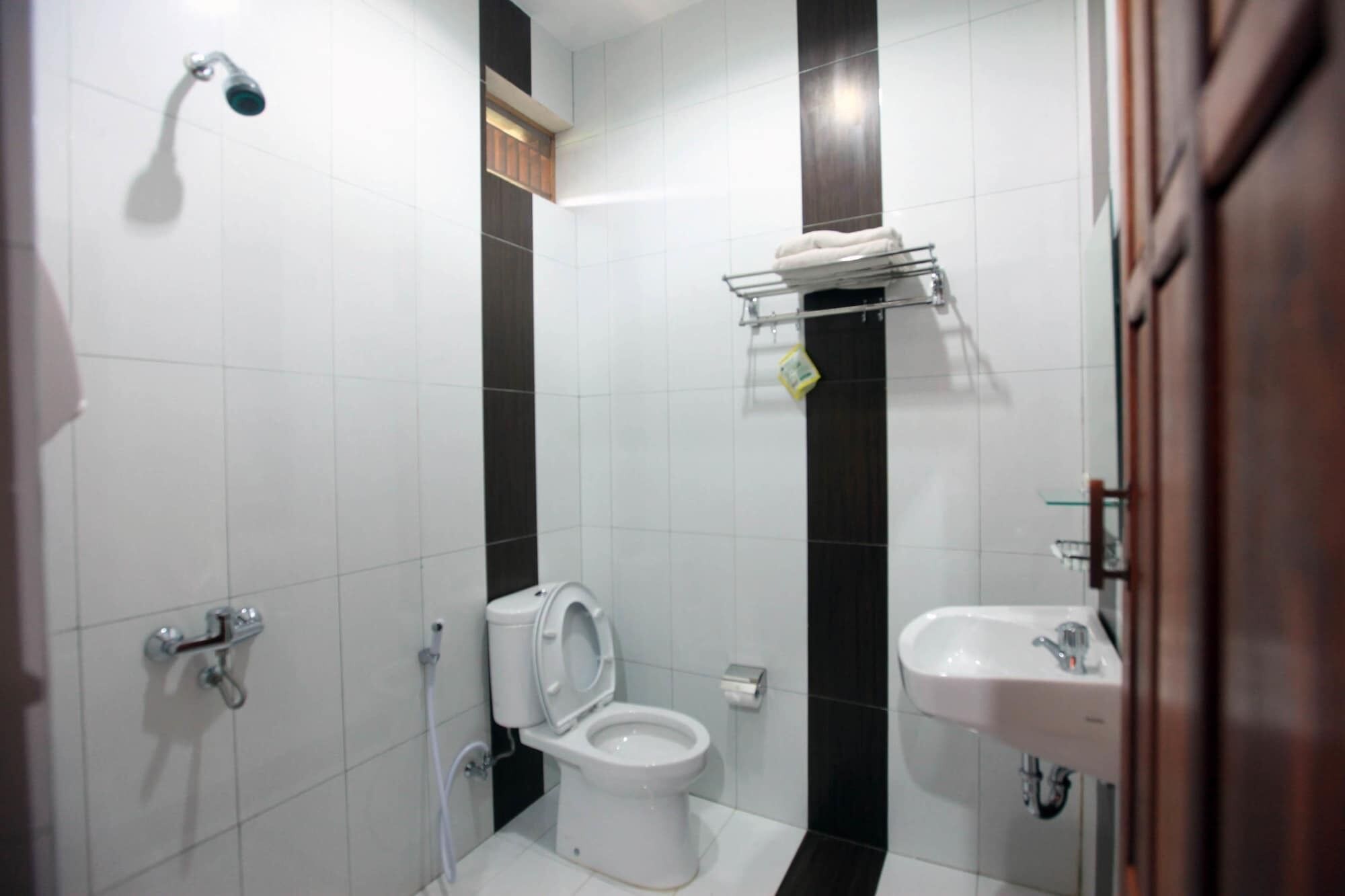 A bathroom with a toilet, a sink, and a shower.