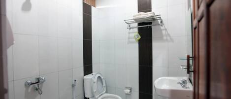 A bathroom with a toilet, a sink, and a shower.