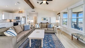 A spacious living area with a large white coffee table, beige sofas, and a blue patterned rug. - Blue Wave 🌊 Beach Front View  🌞 Private Pool 🌴 Most Reviews on SGI (Apalachicola)