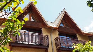 Een gebouw met een houten gevel, balkons en een heldere lucht.