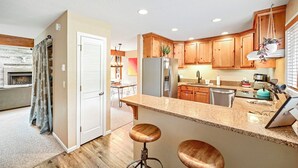 A modern kitchen with wooden cabinets, granite countertops, and stainless steel appliances. - Chic 3-Level Condo w/Private Deck, Hot Tub & BBQ (West Vail)