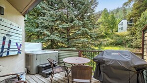 A deck with a hot tub, wicker chairs, a round table, and a grill. - Chic 3-Level Condo w/Private Deck, Hot Tub & BBQ (West Vail)