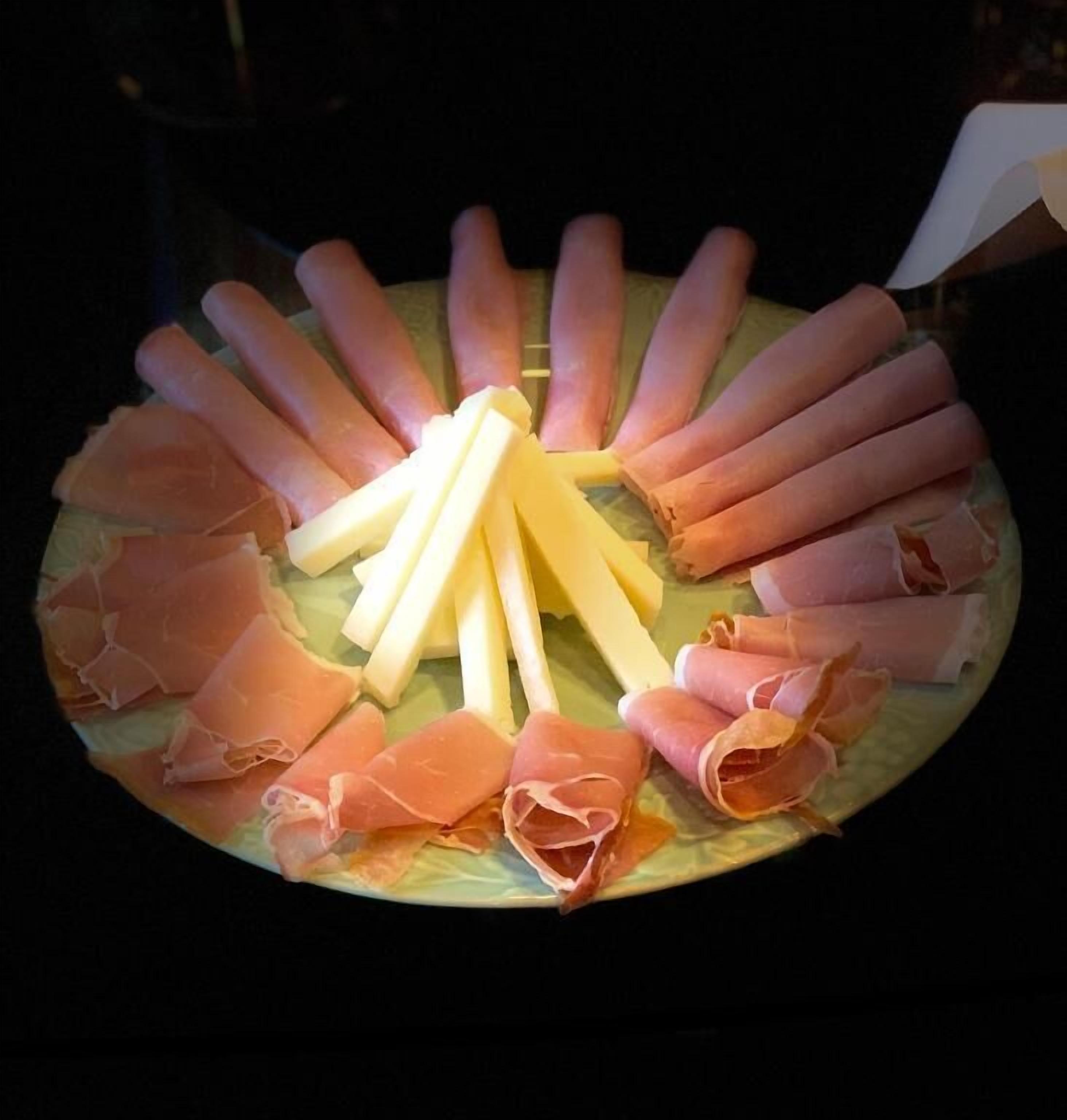 Une assiette de charcuteries et de fromages variés.