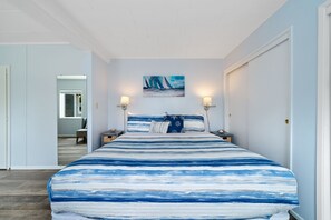 The beachy and beautiful master bedroom has a king-sized bed