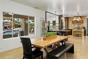 Une cuisine moderne avec un îlot central, une table à manger en bois et des chaises.
