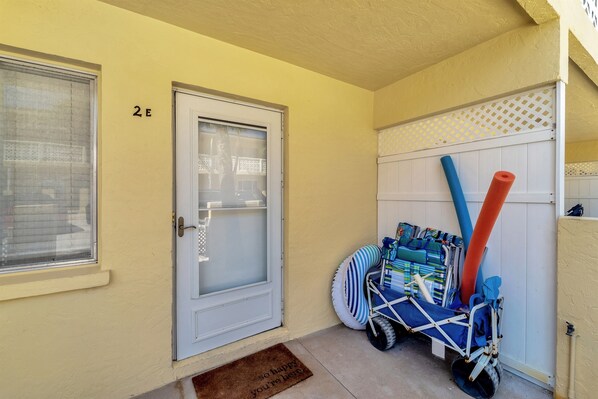 A door with a number, a window, and a door mat.