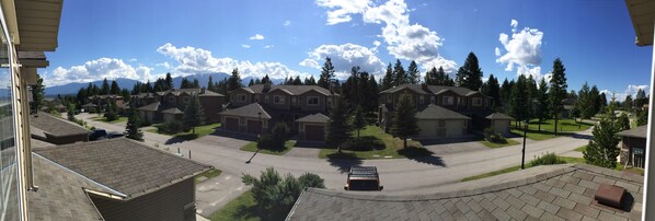 A residential area with houses, a street, and a mountain range in the background.
