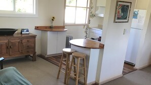 Una habitació acollidora amb un llit, una cuineta petita i una finestra.