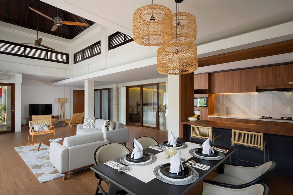 A spacious living area with a dining table set for four, a sofa, and a television in the background.