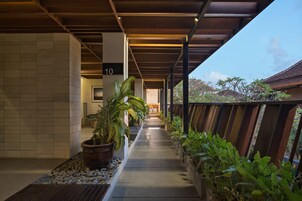 Un pasillo cubierto con plantas en macetas, un letrero con el número 10 y vista al exterior.