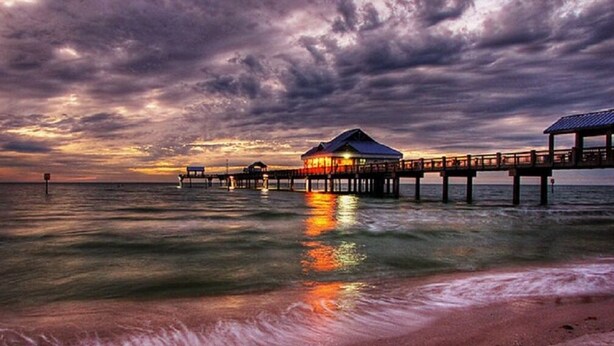 A pier extending into the water with a building at the end.