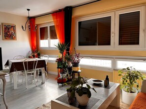 A dining area with a table set for two, surrounded by potted plants and a view of the city through large windows. - Bright and Spacious STUDIO,  40 sqm, cooling unit, Great View, Wifi, TV,  (Paris)