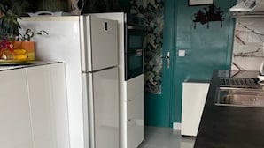 A modern kitchen with white cabinetry, a black countertop, and a teal accent wall. - Bright and Spacious STUDIO,  40 sqm, cooling unit, Great View, Wifi, TV,  (Paris)