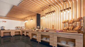 Una mesa de buffet moderna con mostradores de madera, diversas opciones de comida y un diseño de techo original.