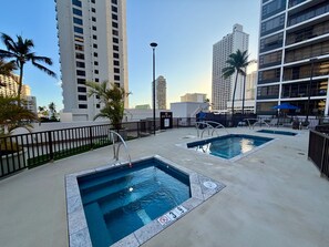 A rooftop pool area with two pools, a no diving sign, and surrounding high-rise buildings. - CLEAN, Diamond Head & Ocean Views, Tower 1, Free Parking. Pool, Lanai, Near Beach & Zoo, (Honolulu)