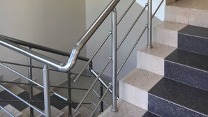A modern staircase with metal handrails and a mix of white and dark tiles. - Budzhaka Black Sea Paradise (Sozopol)
