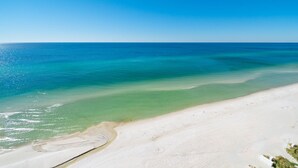 Une plage à l’eau turquoise et au sable blanc.