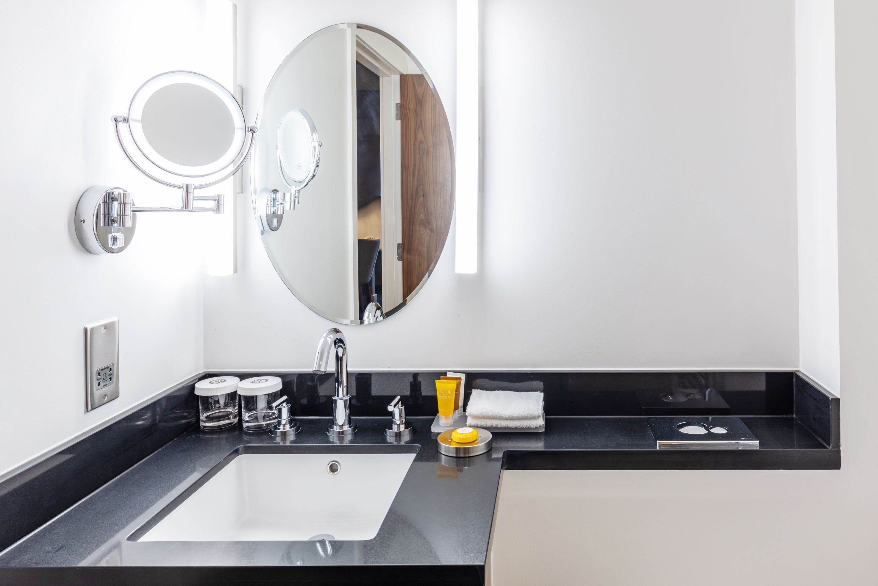 Un baño moderno con un espejo grande, un lavabo y tocador.