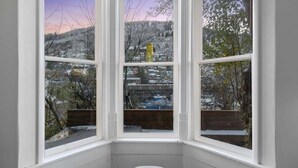 Ein Erker mit Blick auf eine verschneite Landschaft und Gebäude.