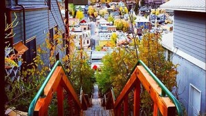 Blick von einer Holztreppe zu einer Stadt mit Häusern und Bäumen.