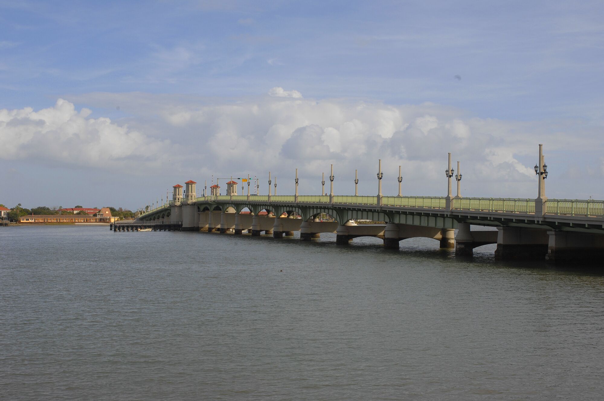 A bridge with multiple arches over a body of water, supported by pillars.