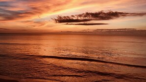 A sunset over a calm sea with a clear horizon.