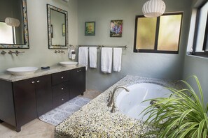 A bathroom with two sinks, a large bathtub, dark cabinets, and a decorative mirror. - Private pool 1-bed close to Cruz Bay Ocean views (St john)