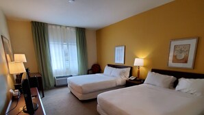 A hotel room with two beds, a desk with a computer, a chair, a lamp, and a framed picture on the wall. - Wingate by Wyndham Uniontown (Uniontown)