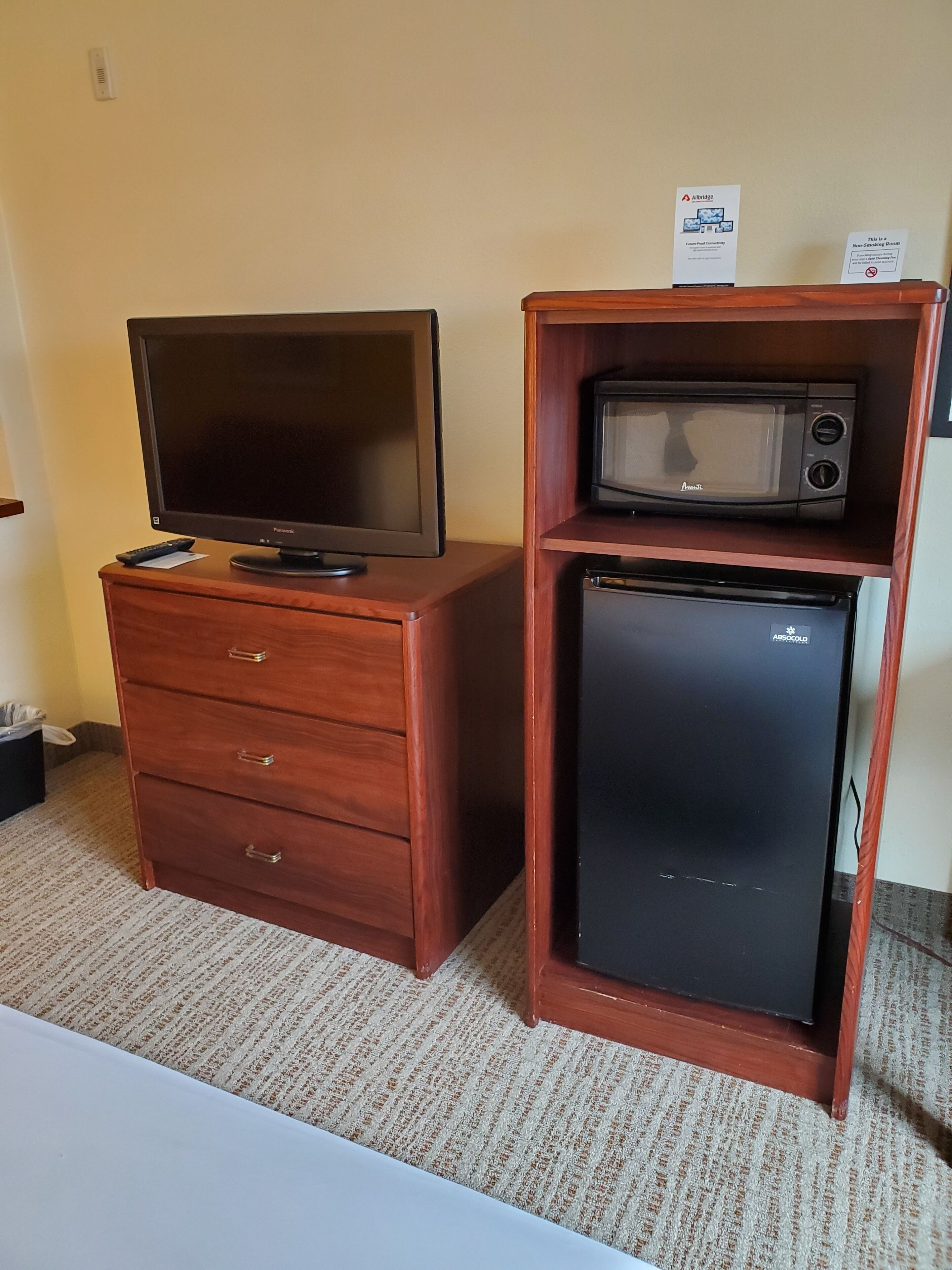 Un aparador de madera con un televisor y un microondas encima.