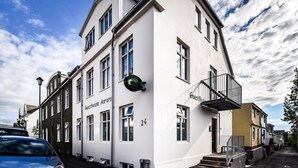 Un bâtiment blanc avec une enseigne indiquant « Guesthouse Aurora » et le numéro « 24 » sur le côté.