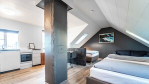 Une chambre de style loft moderne, dotée d’un grand lit, d’un bureau et d’une kitchenette.