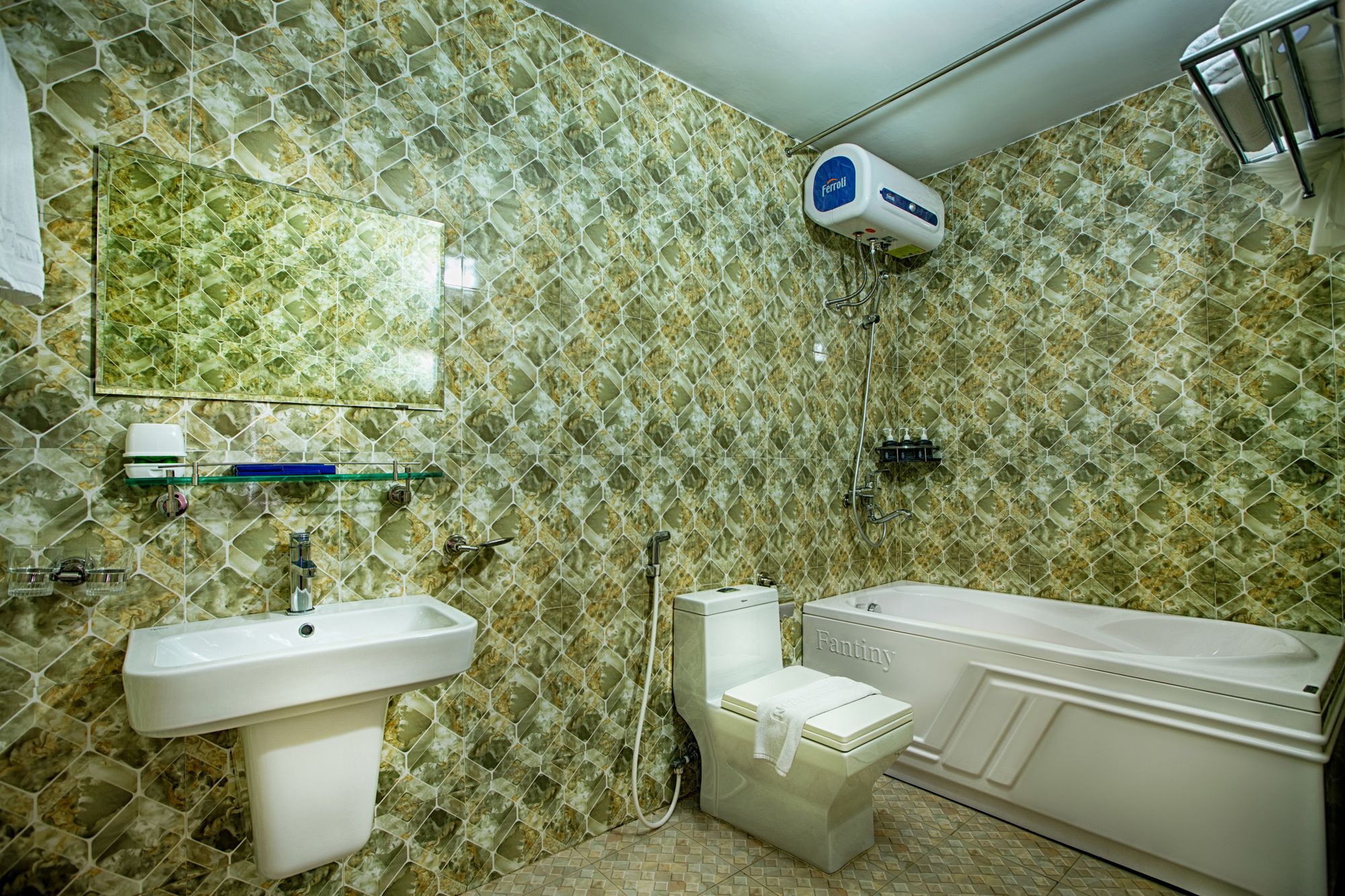 A bathroom with a hexagonal tile pattern, a sink, a toilet, a bathtub, and a mirror.